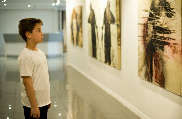 A photo of a child looking at a painting in a gallery.