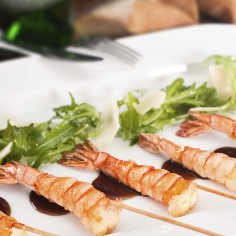 A photo of fine dining starters, skewered prawn tails