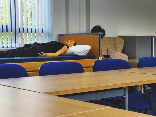 Photo across the training room of a profile bed with mannequin on it