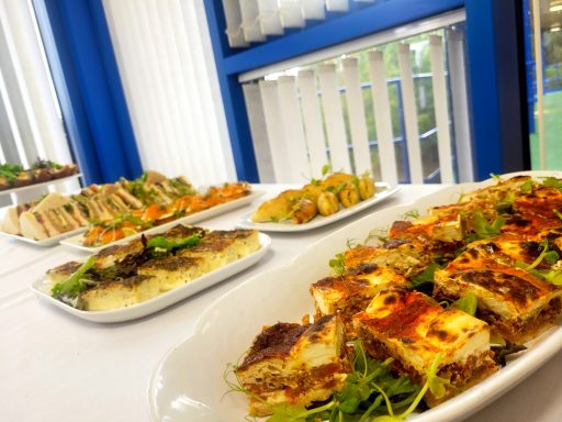 A photo of the quiches platter and several other food options from the buffet lunch table.