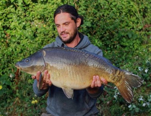 A photo of an angler holding up a mirror carp