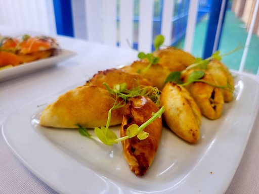 A close up photo of the mini Cornish pasties in the buffet with green garnish.