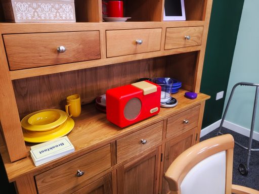 Close up photo of the props in the dining room set of the studio. A radio and plates and cups are on the wall unit