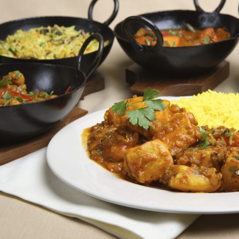 A photo of a curry dish and various accompaniments