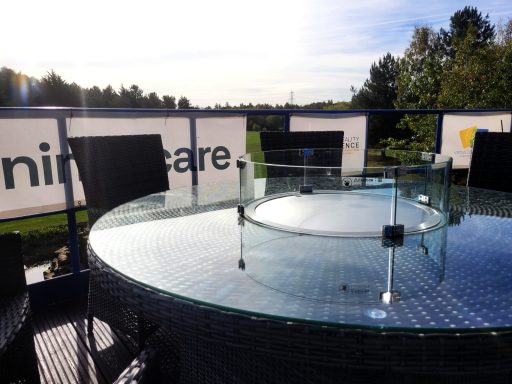 A photo of the round fire pit table on the balcony terrace of the boardroom.