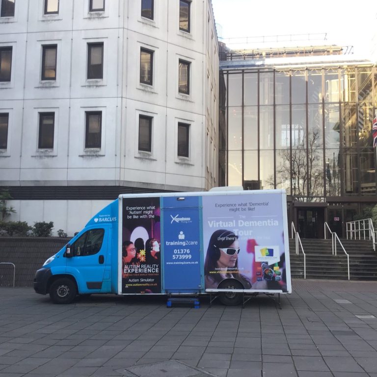 A photo of the mobile virtual dementia tour parked outside a building.