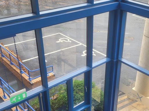 A photo of two disabled parking spaces outside a venue building.