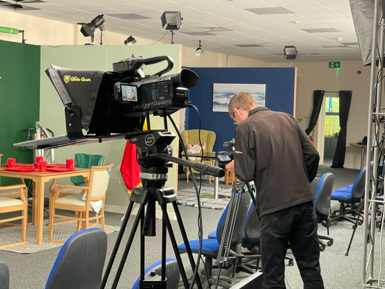 A photo of a film studio with someone checking the view through one of the cameras.