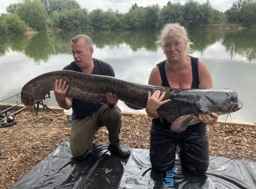 A photo of a male and female anglers holding a 70lb catfish.