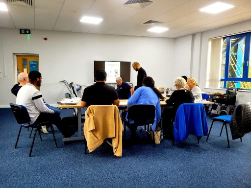 A photo of delegates in a training session listening to the trainer