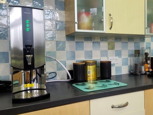 A photo of tea and coffee making facilities in a kitchen with cupboards.