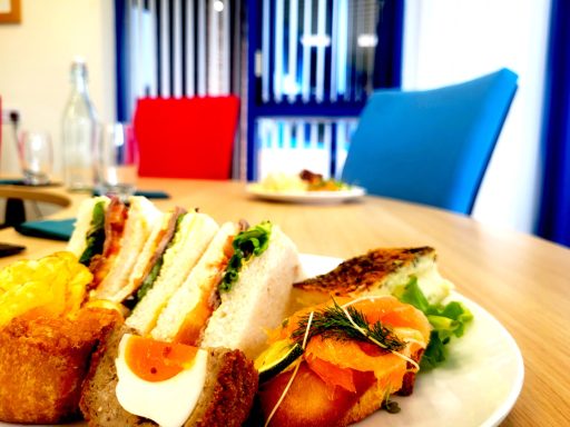 A photo of a plate of lunch with items from the buffet including sandwiches, scotch eggs, smoked salmon and quiche