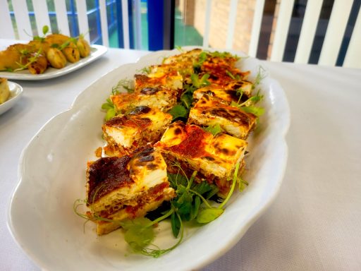 A photo of a plate of quiche fingers.