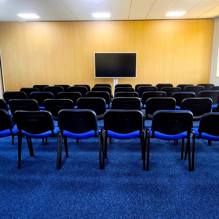 An empty theatre layout for a training room with a 65" interactive smart screen at the front.