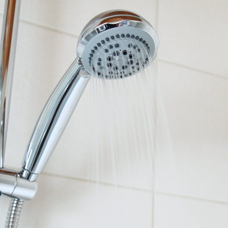 A close up photo of an operating chrome shower head.