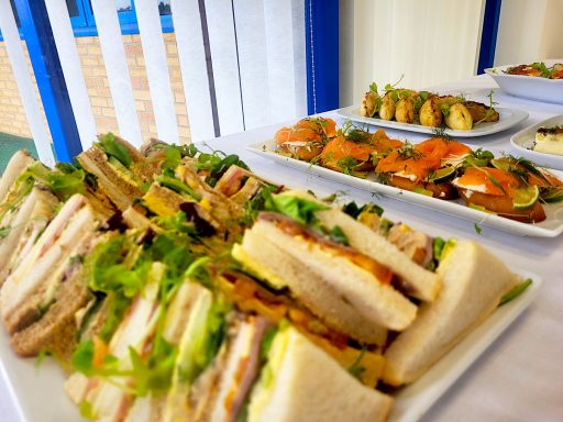 A photo of a sandwich platter with salmon crostini in the background.