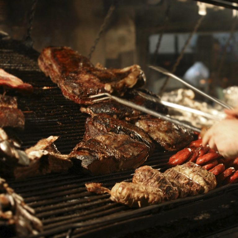 Photo of various meats being cooked on a barbecue