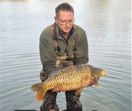 A photo of a man holding a mirror carp