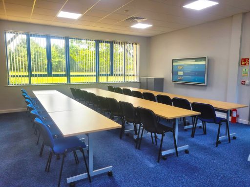 A photo of a classroom layout in training room 3 with 3 rows of tables and chairs