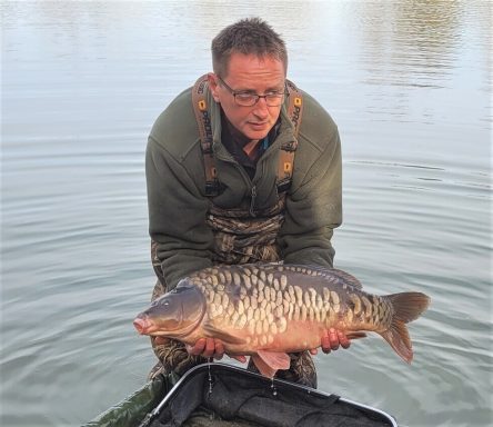 A man holding a mirror carp.